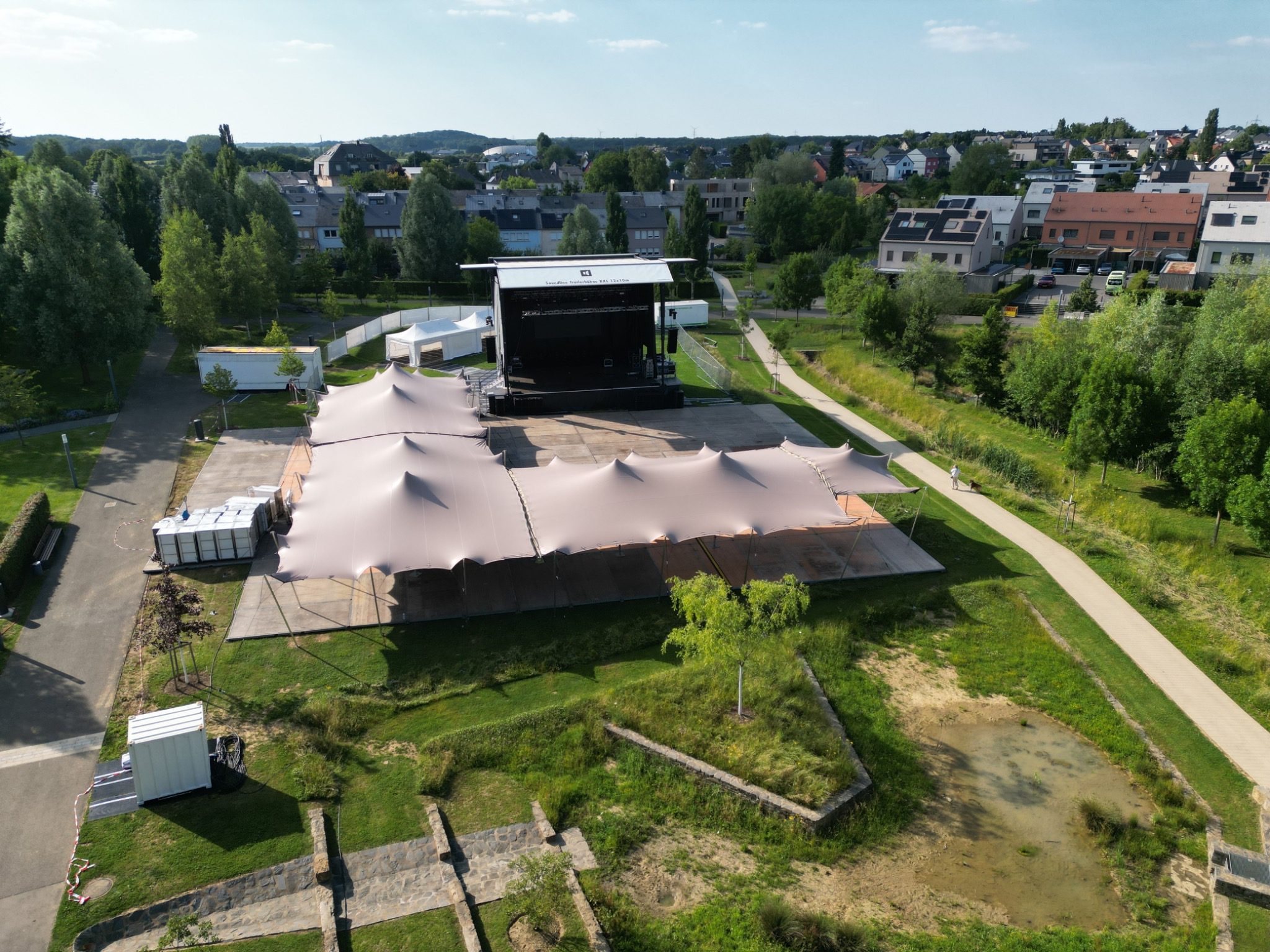 Stretchzelte in L-Form mit erhöhten 4-Meter-Außenpfosten vor einer Open-Air-Bühne – Zeltverleih Brendamour